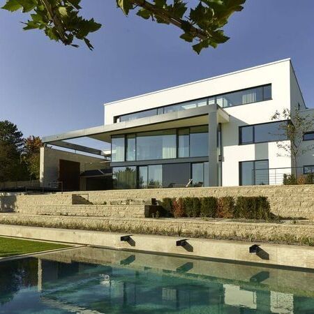 Referenz - moderne Villa mit Steintreppe, die in den Garten und zum Pool führt