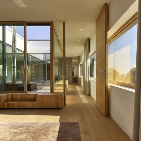 Referenz - modernes Haus mit Holzverkleidungen und großen Fensterfronten