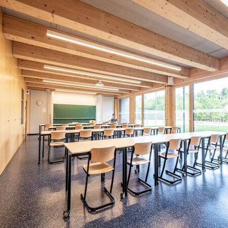 Referenz -  Klassenzimmer mit Holzverkleidung und Fensterfront auf der rechten Seite