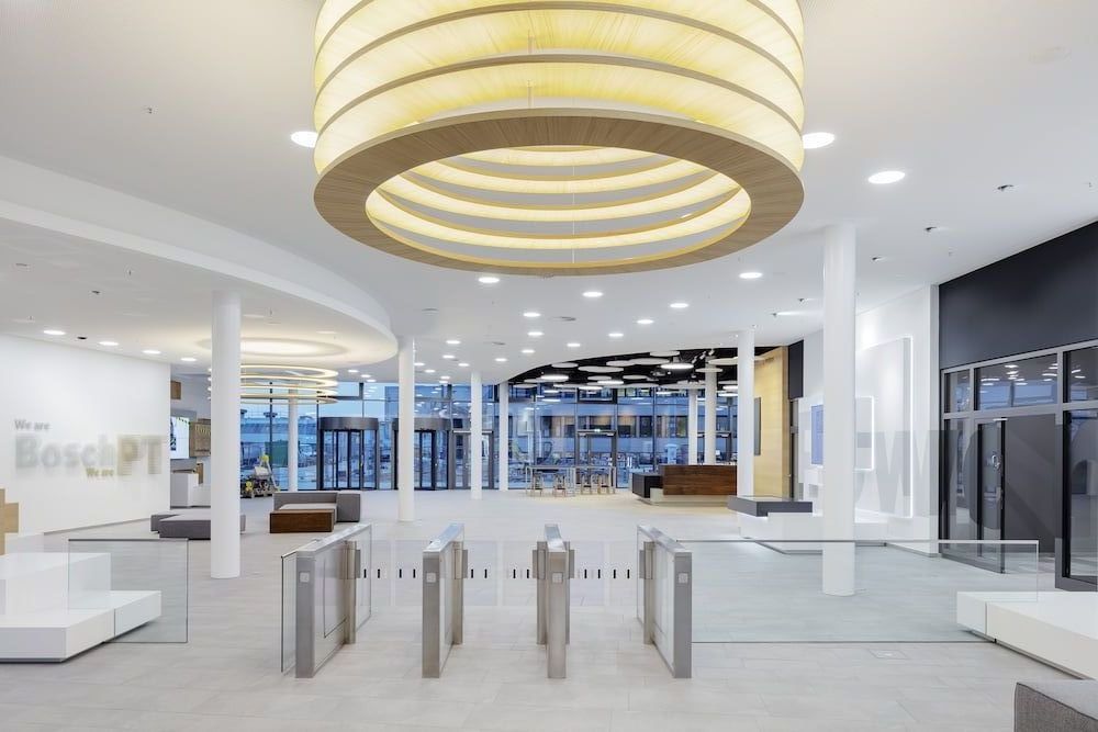 Großzügiges Firmenfoyer mit moderner Lichtarchitektur und Zugangssystem