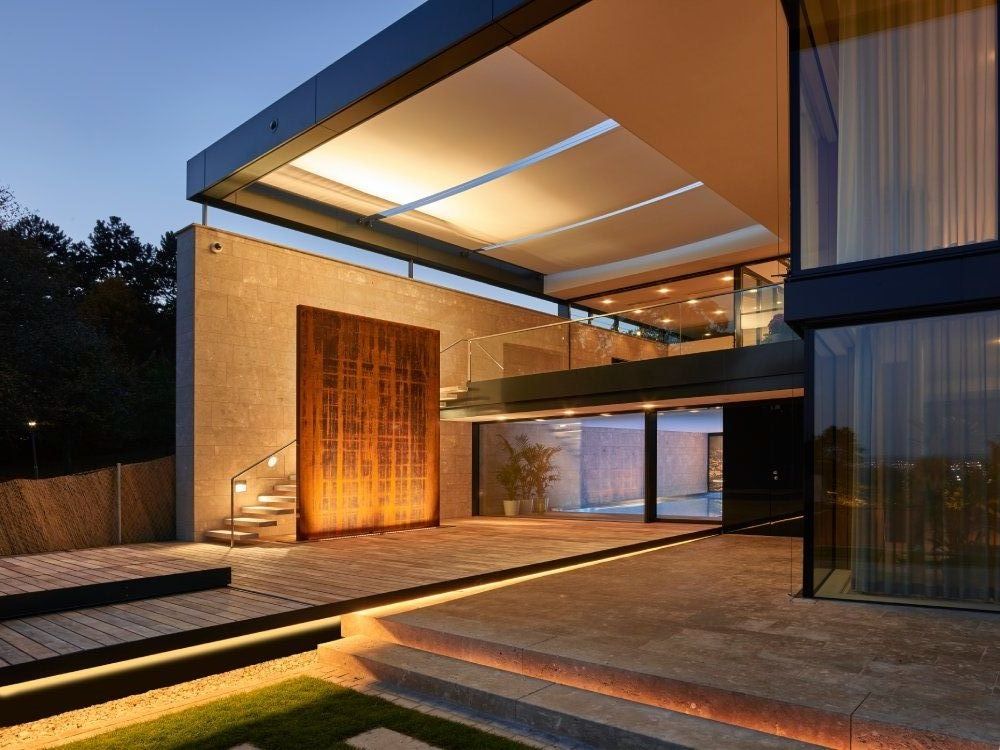 Architektonisches Detail moderner Villa mit Glasfront und Terrassenlicht